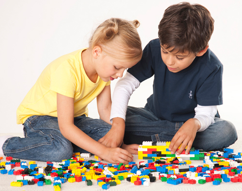 Two children playing with Legos
