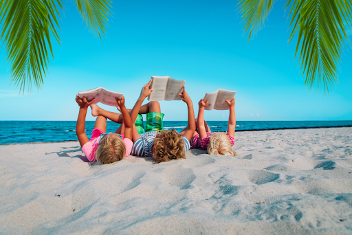 children reading books on the beach