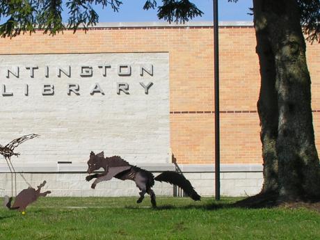 Steel fox chasing prey in front of South Huntington Public Library