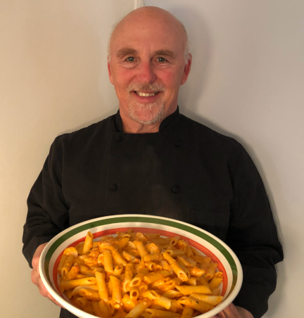 Photo of Chef Rob holding a bowl of Penna all Vodka.