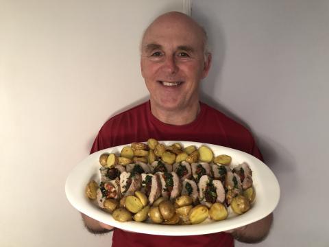 Photo of Chef Rob holding a plate of stuffed pork tenderloin.