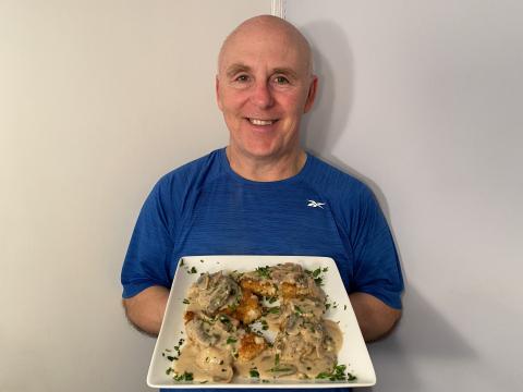Photo of Chef Rob holding a plate of Chicken Schnitzel.