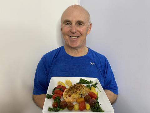 Photo of Chef Rob holding a plate of stuffed salmon.