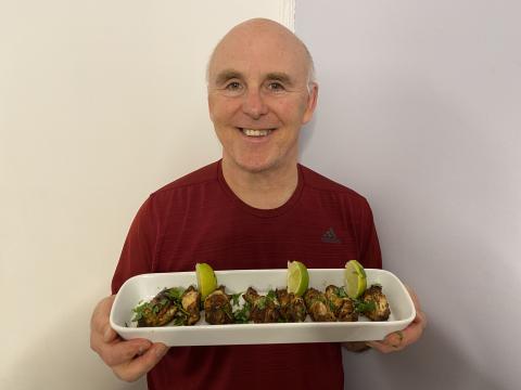 Chef Rob holding a plate of Grilled Sweet & Spicy Chicken Wings.