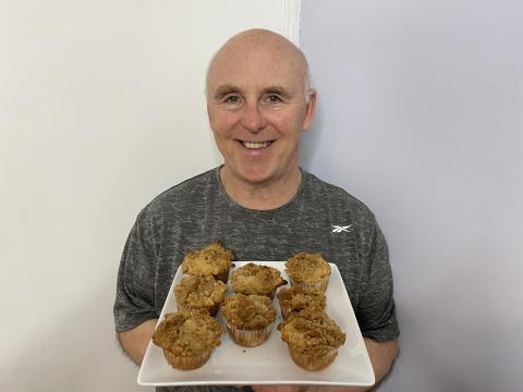 Chef Rob holding a plate of Thanksgiving Apple Pie Crumble Muffins.