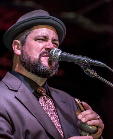 a phot of Harmonica Bill singing at the microphone.
