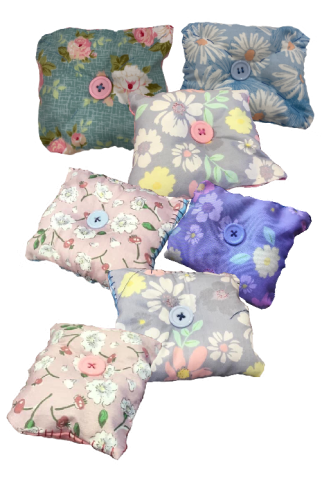 A color photo of several square lavender sachets, each with a button sewn on the top.