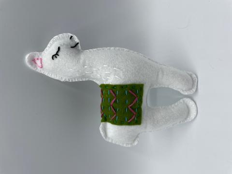 A color photo of a stuffed llama made from felt.