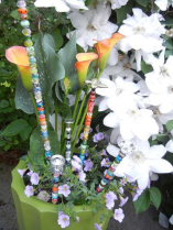 Several fairy sticks in the pot of a white flowering plant. 