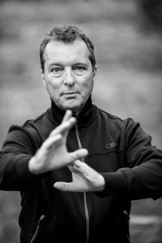 A black and white photo of Bill Donnelly in a Tai Chi pose.