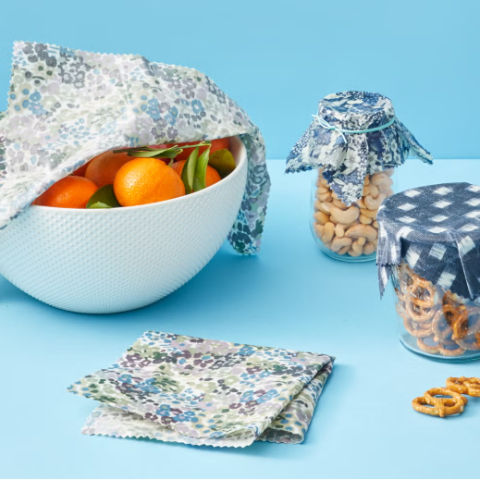 A photo of a bowl and jars covered with beeswax food wrap.