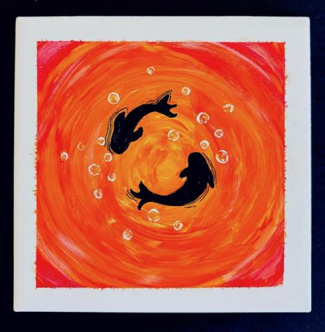 A photo of a painted tile with an orange background and two koi fish.