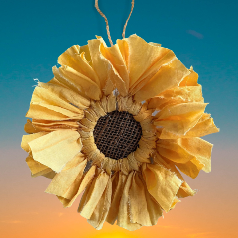 A photo of a sunflower made of fabric.