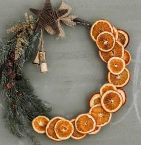 A color photo of a grapevine wreath adorned with orange slices.