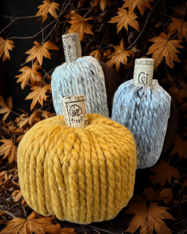 A color photo of three yarn wrapped pumpkins.