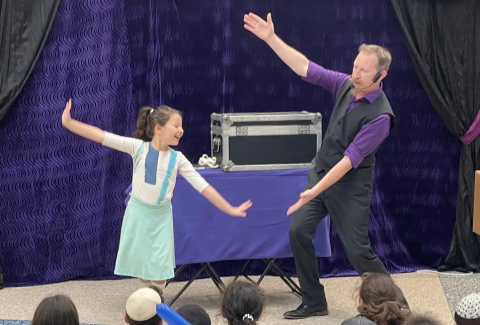 A photo of John Reid and a student on the stage.