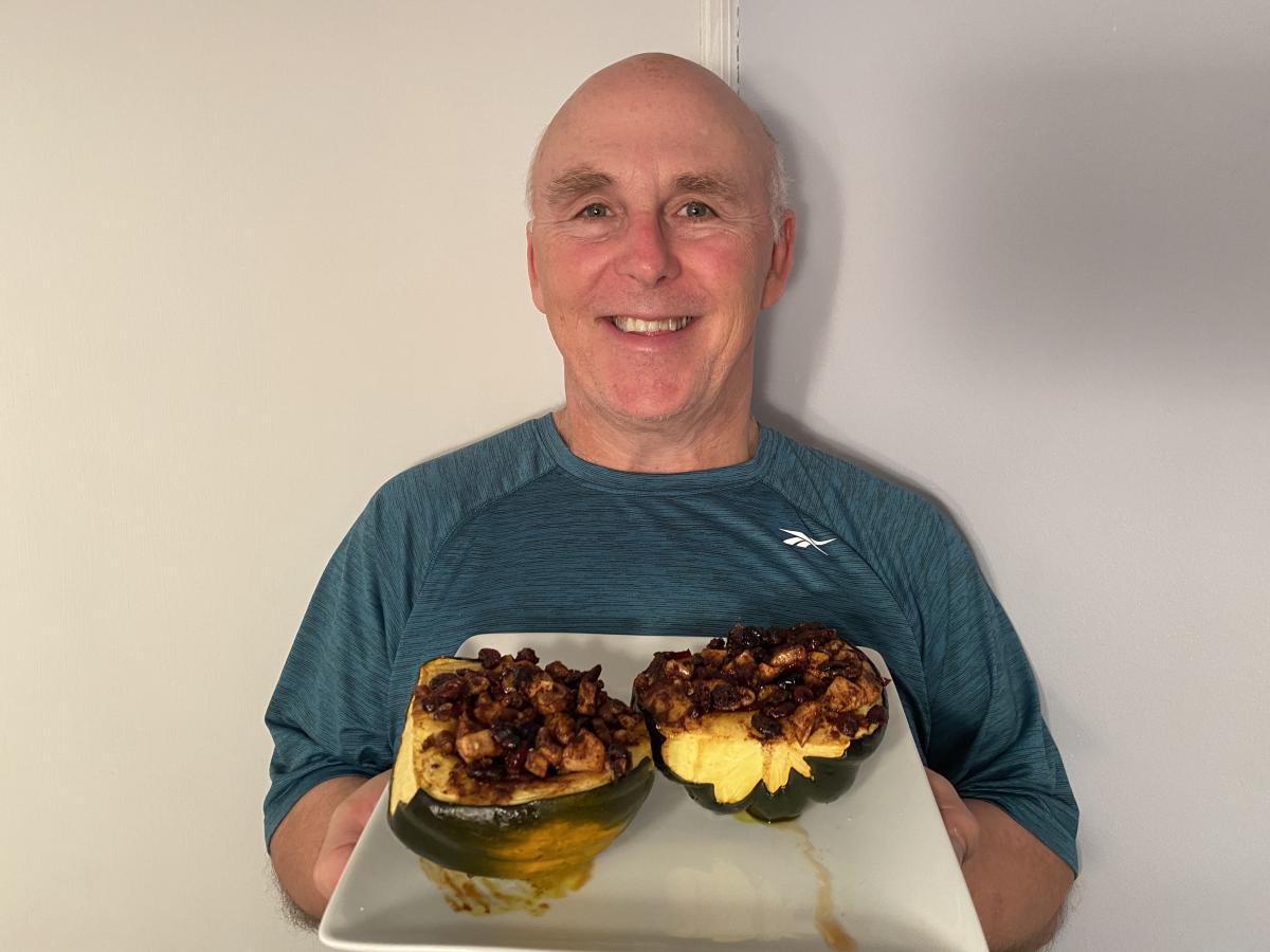 Chef Rob holding a plate of stuffed acorn squash.