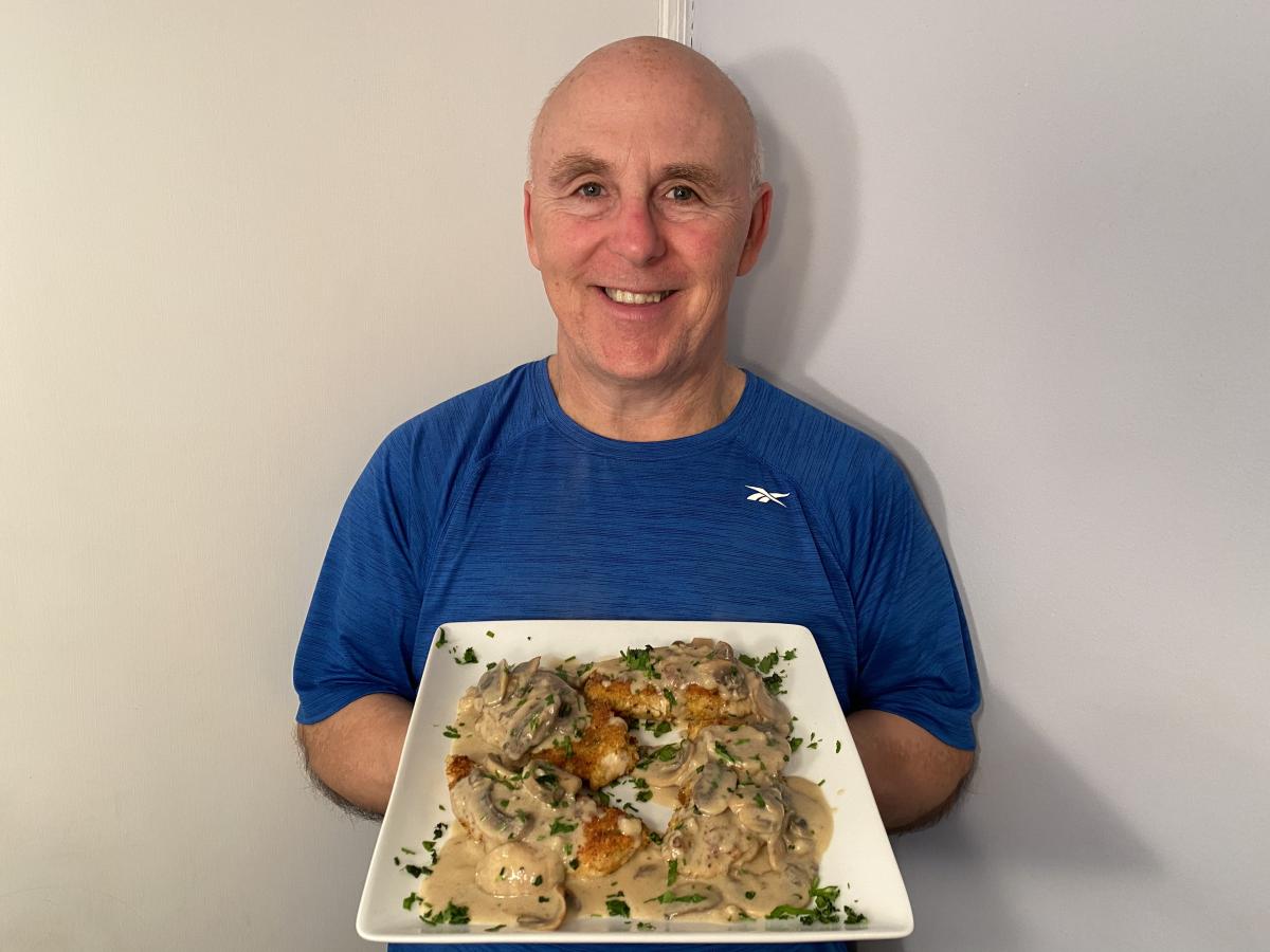 Photo of Chef Rob holding a plate of Chicken Schnitzel.