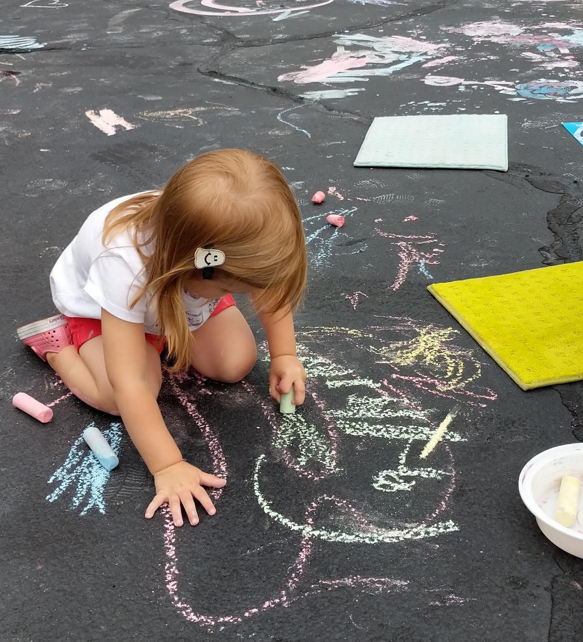 Girl playing with sidewalk Ccalk