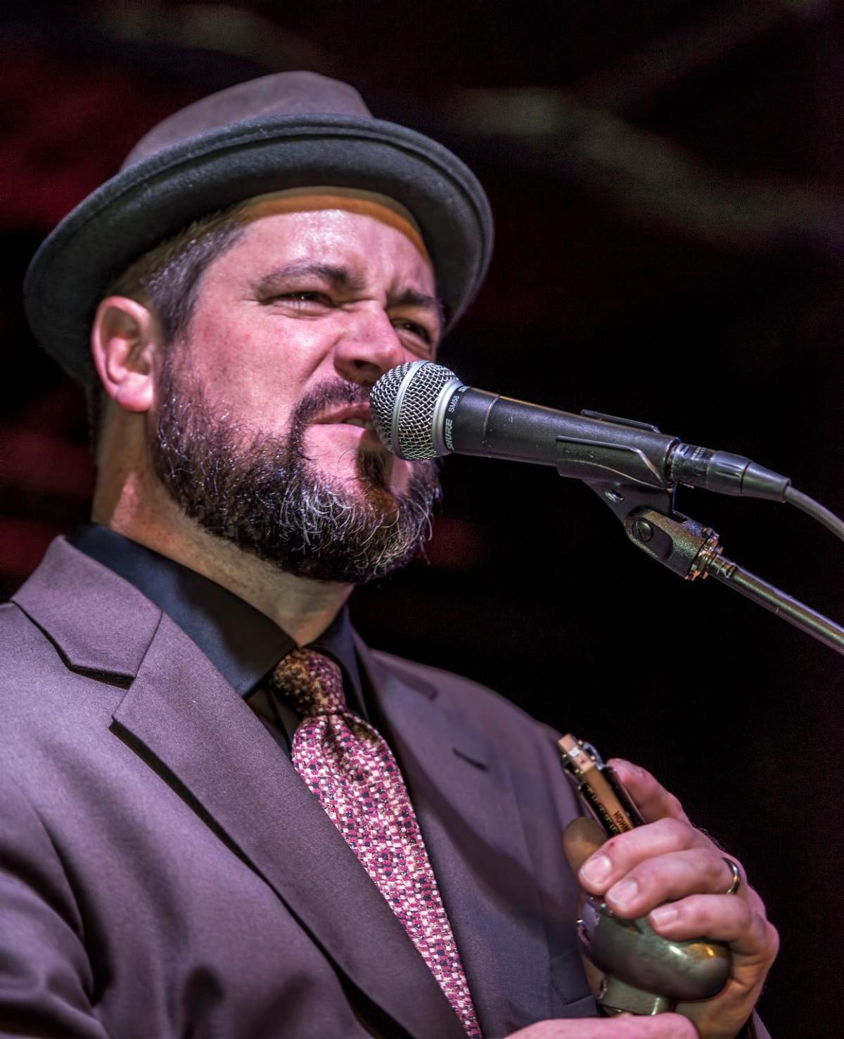 a phot of Harmonica Bill singing at the microphone.
