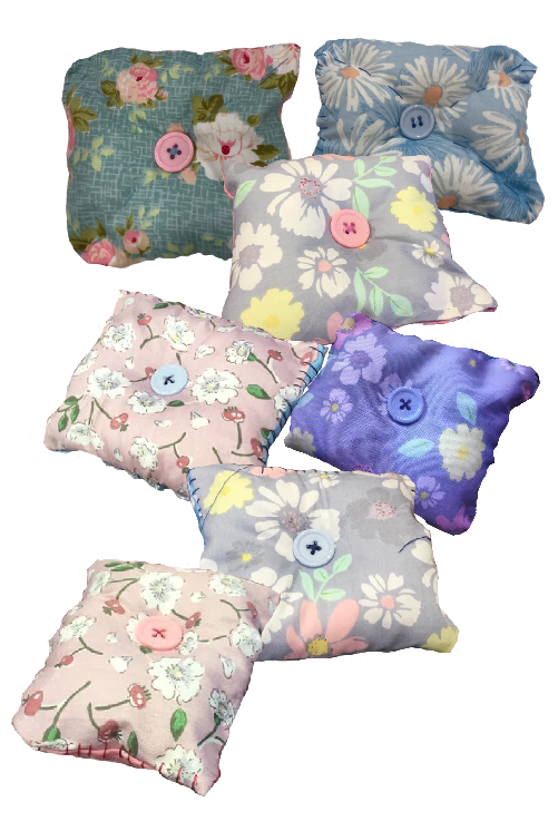 A color photo of several square lavender sachets, each with a button sewn on the top.