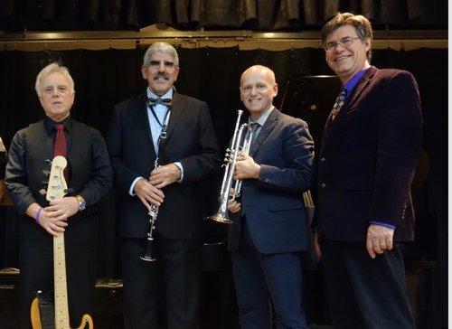 A color photo of the four members of the Paul Effman Band, some holding their instruments.