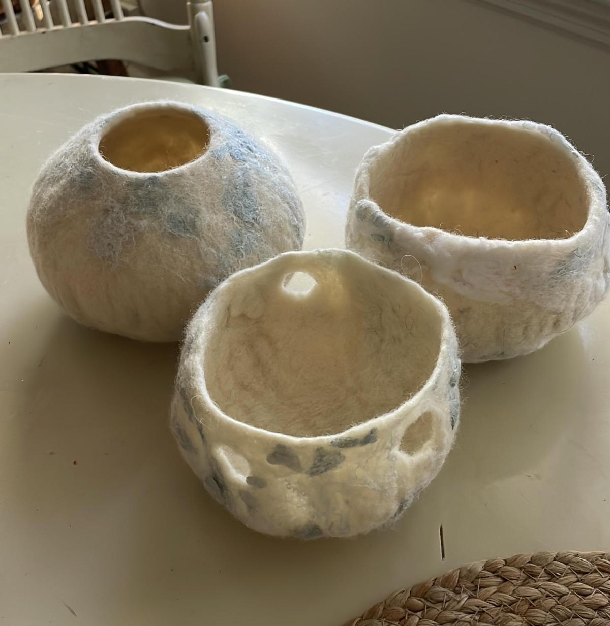A photo of three containers made using the technique of nuno felting.