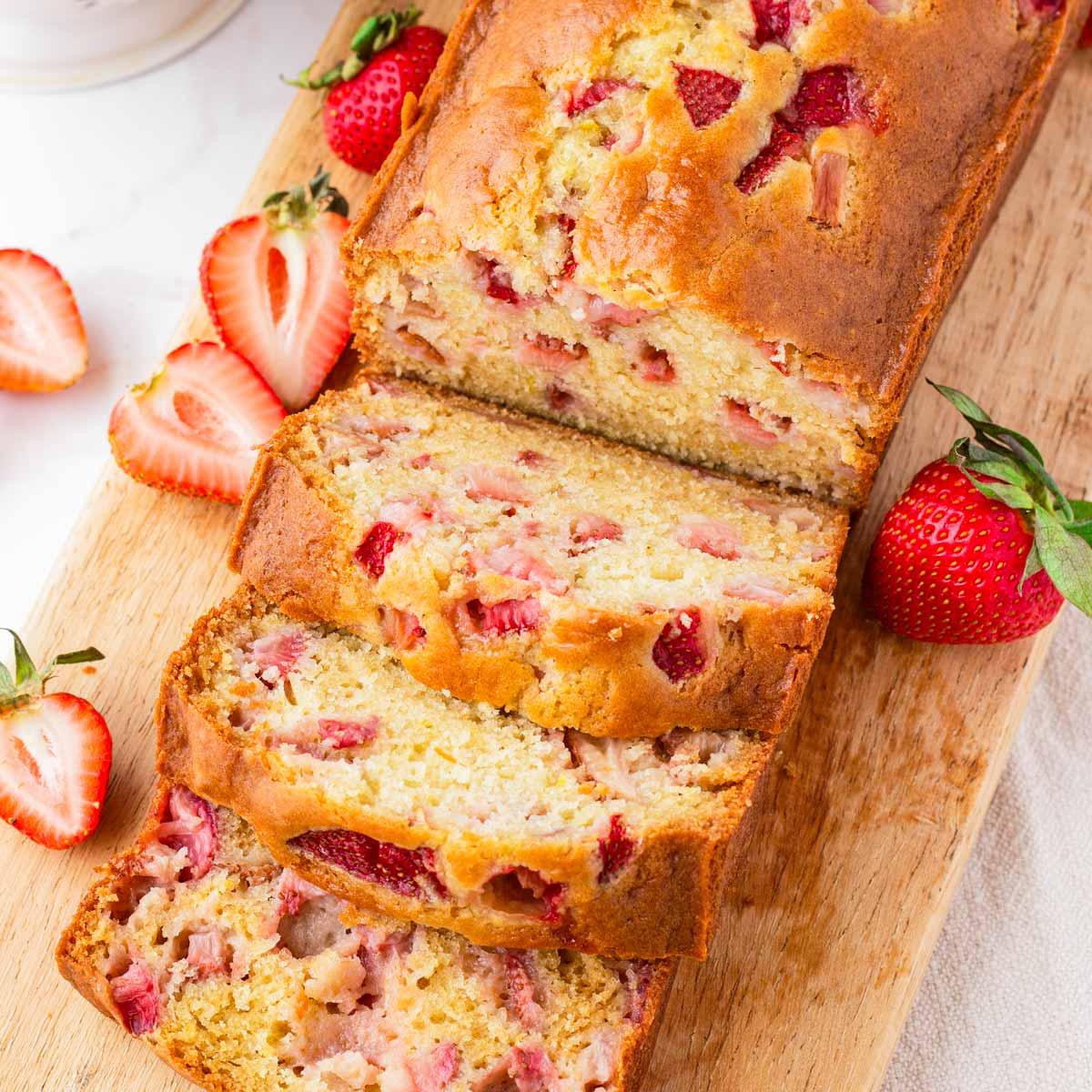 A color photo of a loaf of partially sliced strawberry bread.