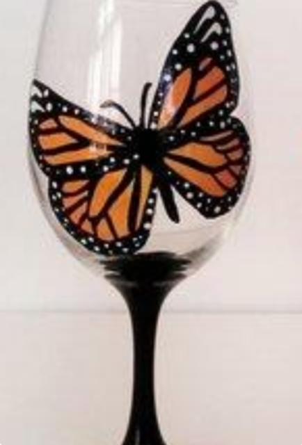 A photo of a wine glass painted with a butterfly.