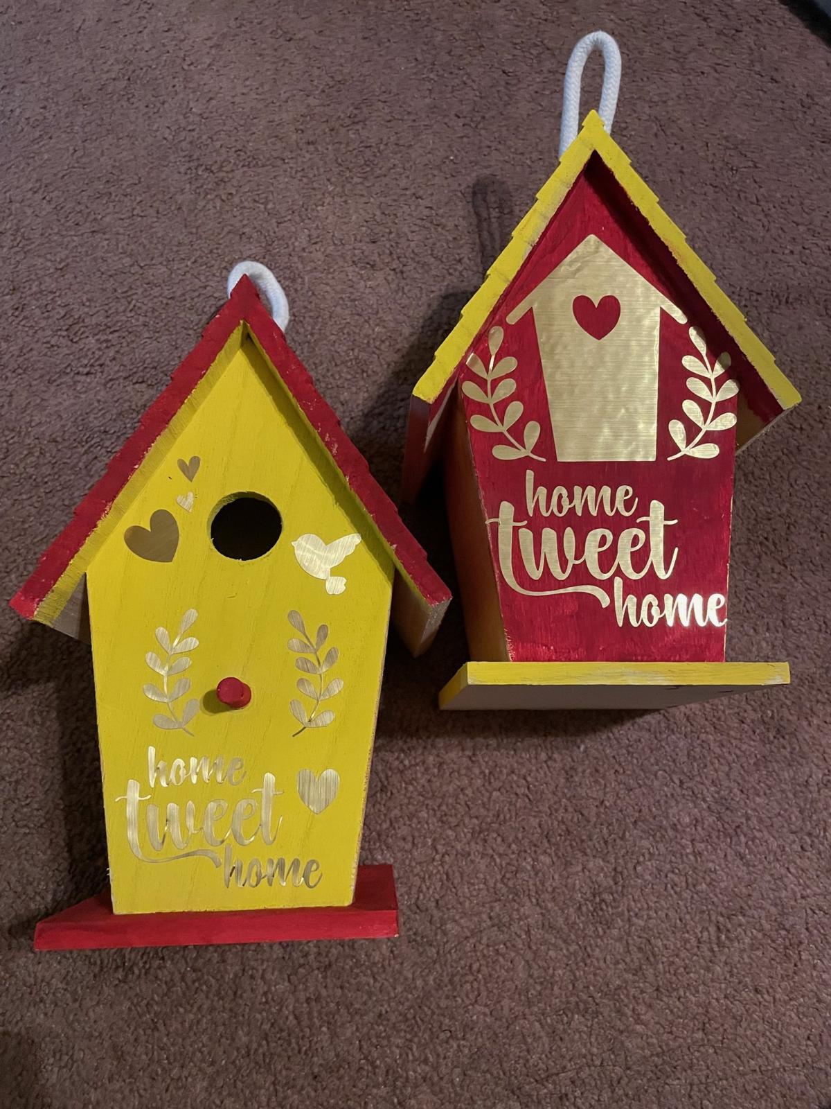 A photo of two birdhouses decorated using Cricut cutouts.