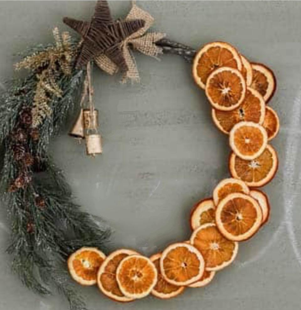 A color photo of a grapevine wreath adorned with orange slices.
