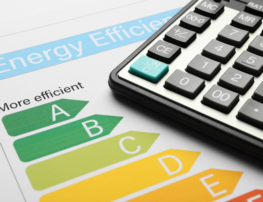 Close-up of a calculator on top of a paper with an "Energy Efficiency" label. The label shows a colored scale from A to E, with green "A" being the most efficient and red "E" being the least.